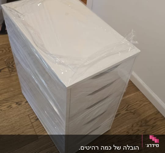 ארון עטוף בניילון על רצפת עץ